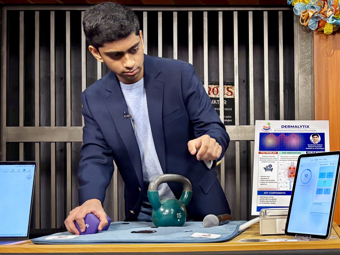 Ayushmaan Bellum demonstrating the Dermalytix pressure-sensing mat live, with weights on the sensor mat and the monitoring app on an iPad